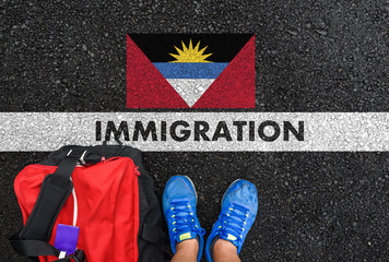 Man in shoes with bag standing next to line with word IMMIGRATION and flag of Antigua and Barbuda...