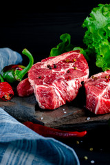 Meat concept. Meat steaks are ready to cook with vegetables lying on the table