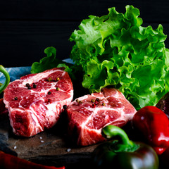 Meat concept. Meat steaks are ready to cook with vegetables lying on the table