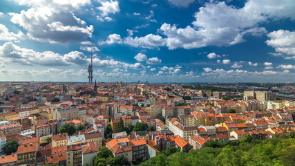 Fototapeta premium Timelapse view from the top of the Vitkov Memorial on the Prague landscape on a sunny day with the famous Zizkov TV tower on the horizon
