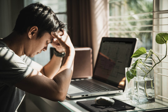 Businessmen Are Worried About The Work And The Economic Downturn. Tired And Worried Business Man At Workplace In Office Holding His Head On Hands.