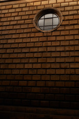 Old styled building from yellow bricks with rounded window on it