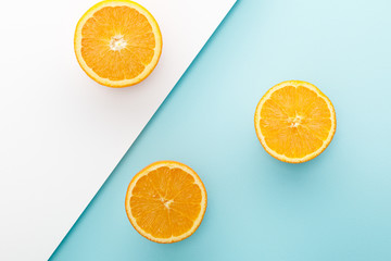 Top view of oranges halves on white and blue background