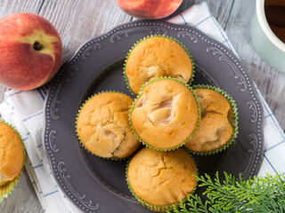 Vegan eggs free spelt wheat muffins with peaches and apples in green paper cases on checkered napkin