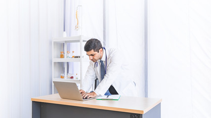 Fototapeta premium Asian doctor in gown uniform working in seriously at hospital or medical clinic