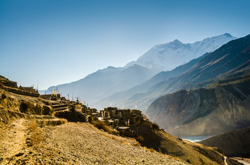 Ghusang (Gunsang) village in Marshyangdi river valley in sunny morning. View from trekking route to Torung La, Annapurna circuit trek, Nepal.