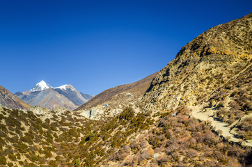 Trekking route from Manang village to Ledar in autumn sunny day. Annapurna circuit trek, Nepal.
