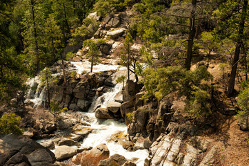 Obraz premium Scenic early spring landscapes with small waterfalls and rocks around in Yosemite National Park, Yosemite, California, USA. Mountain river full of water. Travel destination Yosemite, CA