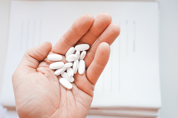 Medicine pills or capsules in hand, palm or fingers of a doctor or nurse. Drug prescription for...