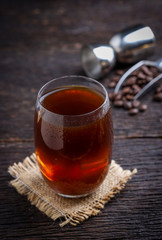 cold brew coffee into glass on wooden table.