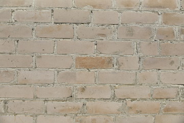 Old shabby, wrecked brick wall with grey cement mortar as background