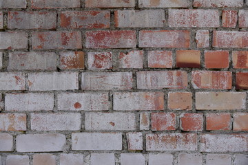 Old shabby, wrecked brick wall with grey cement mortar as background