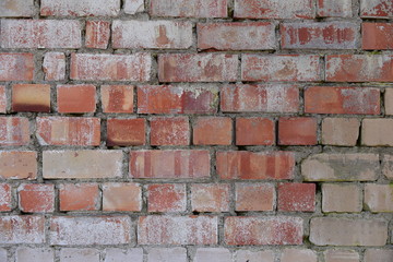 Old shabby, wrecked brick wall with grey cement mortar as background