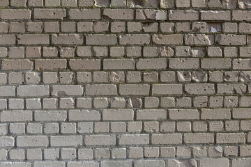 Old shabby, wrecked brick wall with grey cement mortar as background