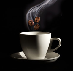 Roasted coffee beans. Seeds of freshly roasted coffee with smoke. Coffee beans closeup with emphasis on the grain with smoke.