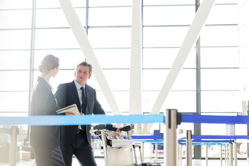 Mature businessman talking with his business partner in check in are at airport
