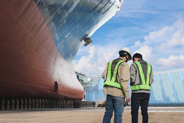 Team worker in floating dry dock in Shipyard for ship repair low angle front cargo ship, surveyor...