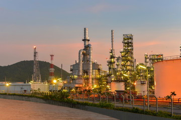 Oil and gas industrial, Oil refinery plant from industry, Refinery Oil storage tank and pipe line steel on sunset, twilight bacckground