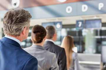 Business people queueing for check in at airport