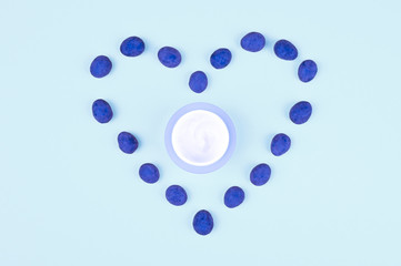Cream in the form of a heart on a blue background. Close Empty space for text or logo. floral background. heart on blue.