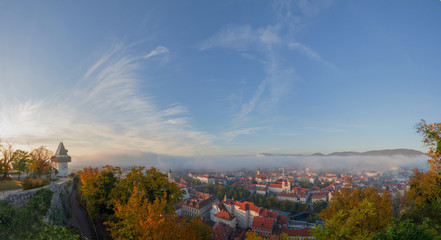 Cityscape of Graz and the famous clock tower (Grazer Uhrturm) on Shlossberg hill, Graz, Styria region, Austria, in autumn. Panoramic view.