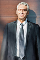 Portrait of Smiling mature businessman standing in suit