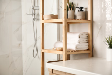 Shelving unit with clean towels in bathroom interior