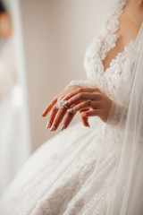 Close-up of tender ring on bride's hand with beautiful manicure. Bride looked at the ring while waiting for groom.