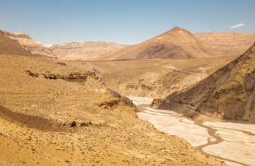 Fototapeta na wymiar A view of the rocky canyons and cliffs towering over the river bed of the Kali Gandaki river in Upper Mustang in the Nepal Himalaya.