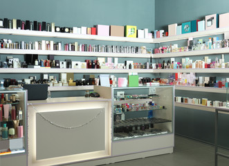 Counter and shelves with perfume bottles in shop