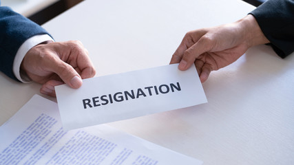 Businessman sending resignation letter to the executive employer boss on desk in order to resign dismiss contract, job placement and vacancies concept.