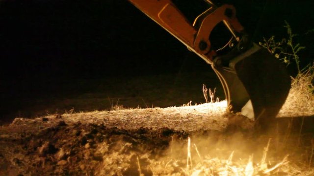 Bulldozer digs at night in the dark, work around the clock, medium shot