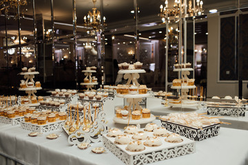 Sweet table. A plates of cakes and muffins. Table with sweets, buffet. Dessert table for a party goodies for the wedding. Candy bar. Decorated delicious