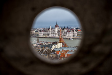 look through a hole in fishermans bastion on Buda Castle Hill, Budapest with Hungarian Parliament Building