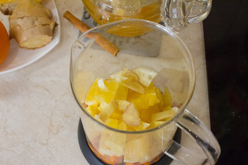 Vitamin useful sea buckthorn tea in a glass teapot with fresh sea buckthorn berries, orange, cinnamon sticks and honey. The concept of rest, relaxation. top view with a copy of the space