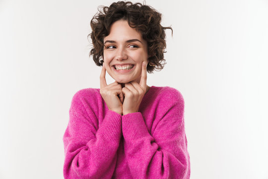 Image of happy woman smiling and pointing finger at her cheeks