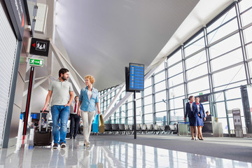 Fototapeta premium Portrait of mature couple walking while talking in airport