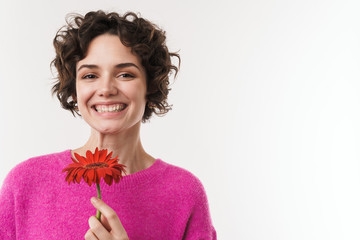 Image of cheerful beautiful woman smiling and holding flower