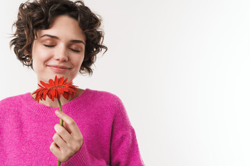Image of pleased beautiful woman smiling and holding flower