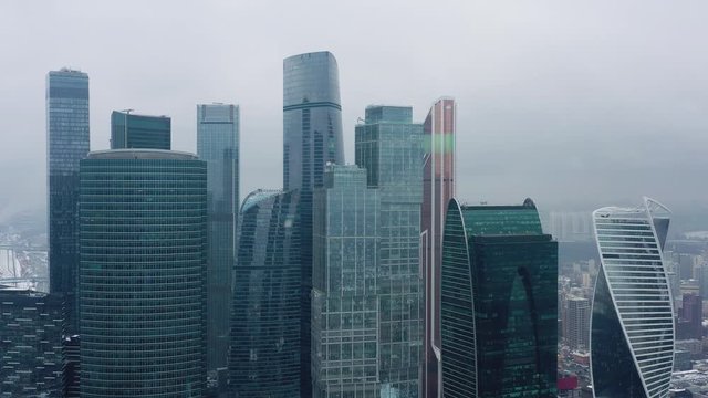 Aerial drone shot flying over center of Moscow city buildings, skyscrapers at cloudy winter day. Drone shot flying over Moscow skyscrapers.