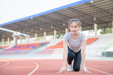 Asian cute athlete on a race track is ready to run,