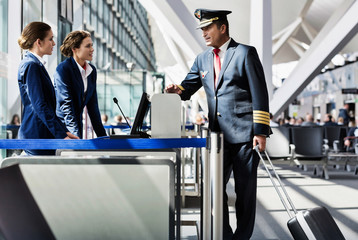 Portrait of mature pilot talking with the airport staffs in boarding gate © MDBPIXS
