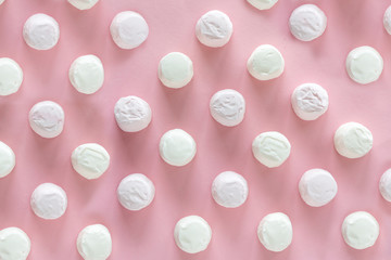 Background or texture of pink and white mini marshmallows on pink background
