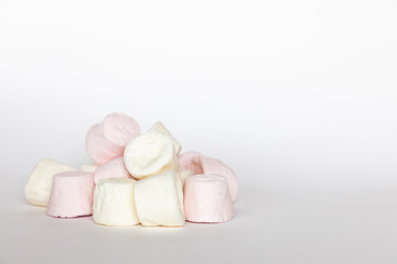 Pink and white mini marshmallows on white background, sweet food
