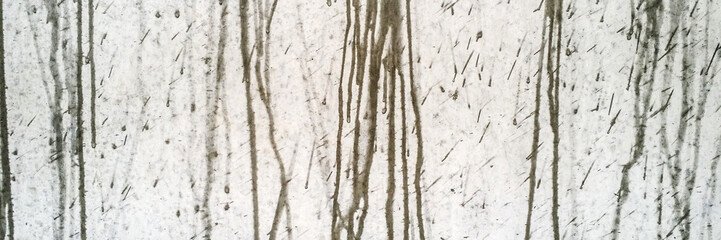Raindrops splash on a gray concrete wall