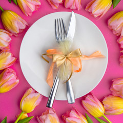 Easter table cutlery with tulips, feathers and bow