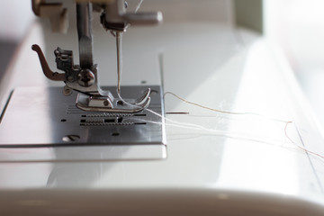 a white sewing machine foot and needle, close up
