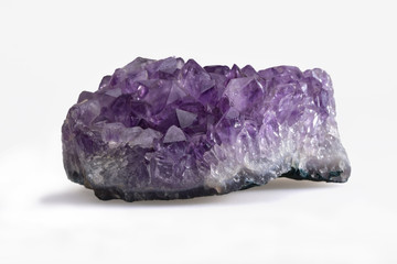 Fototapeta premium Small amethyst cargo with polyhedral crystals on a contrasting white background