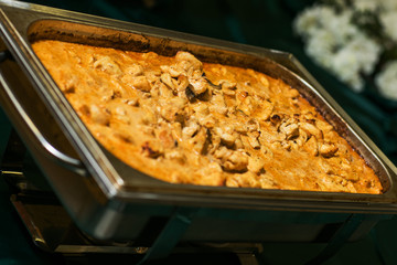 Tasty rustic French food: chicken with mushrooms stewed in sauce close-up on the table.