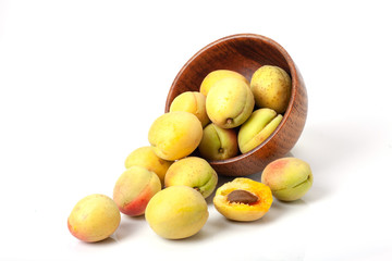 Fresh ripe apricots in wooden bowl isolated on a white background.